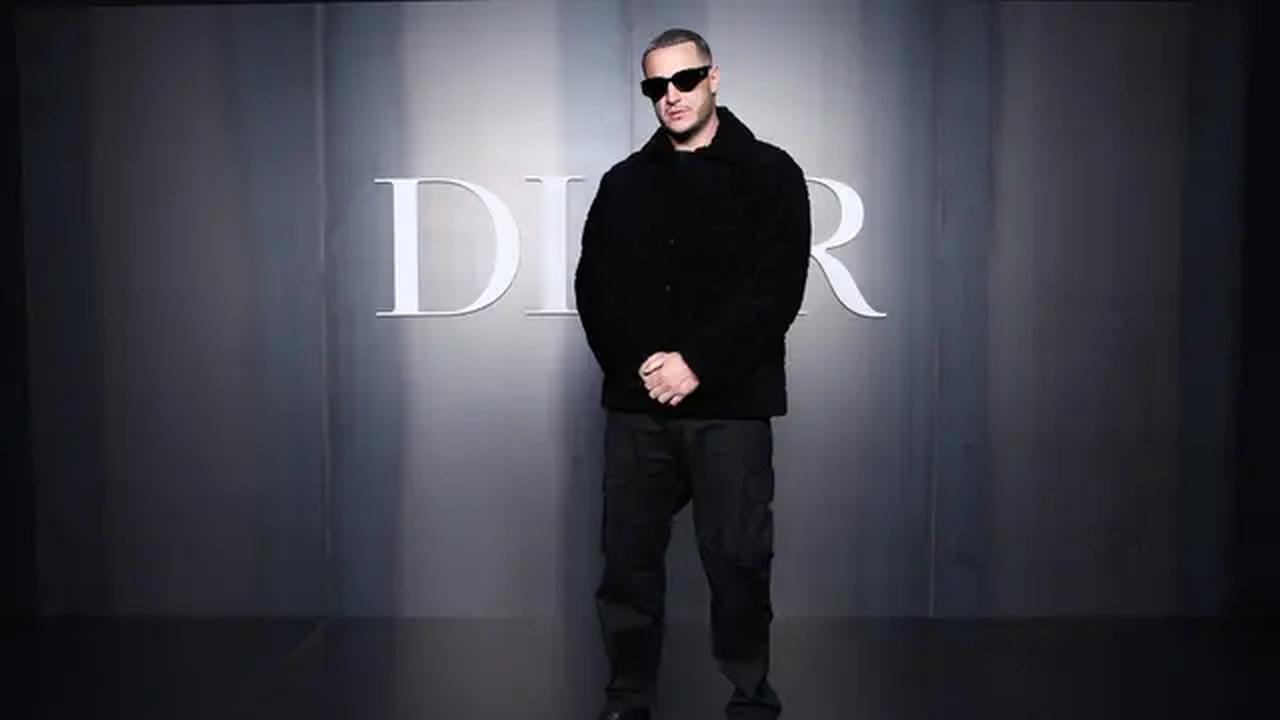 DJ Snake, musisi asal Prancis ini tampil edgy dengan outfit serba hitam, terdiri dari long coat, long pants, dan sepatu pantofel berwarna senada. Tak lupa, ia melengkapi tampilan dengan kacamata hitam yang semakin memperkuat kesan misterius dan stylish. [Dok/DIOR].