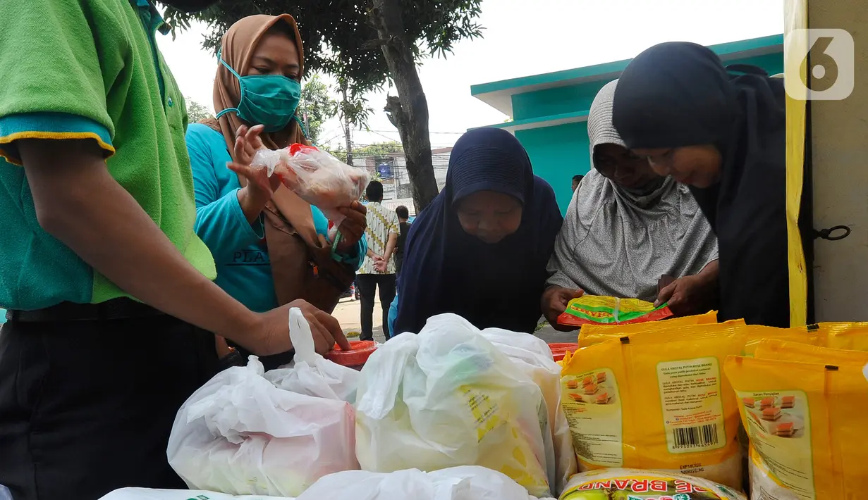 Warga membeli bahan kebutuhan pokok dengah harga di bawah harga eceran tertinggi (HET) saat kegiatan operasi pasar di Kantor Kelurahan Sawah, Tangerang Selatan, Banten, Kamis (29/9/2022). Dinas Perindustrian dan Perdagangan (Disperindag) Kota Tangerang Selatan menggelar operasi pasar di tujuh kecamatan dalam rangka penanganan inflasi sebagai dampak kenaikan harga bahan bakar minyak (BBM). (merdeka.com/Arie Basuki)
