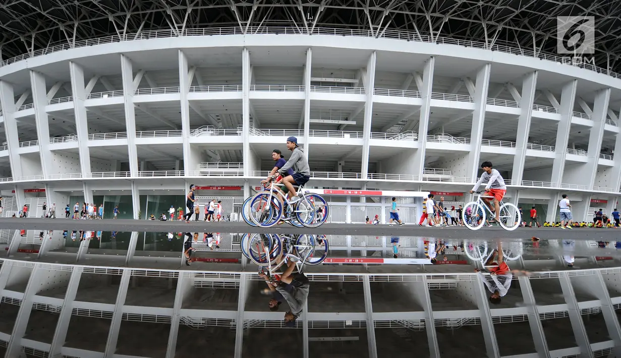 Warga bersepeda di kawasan lingkar luar Stadion Gelora Bung Karno (GBK), Jakarta, Minggu (21/1). Pascarenovasi, kawasan sekitar Stadion GBK kembali dipadati warga yang berolahraga. (Liputan6.com/Helmi Fithransyah)