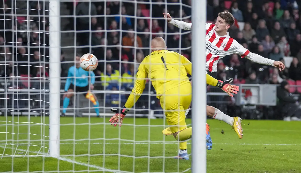 <p>Kiper Sevilla, Marko Dmitrovic berusaha menghalau bola dari ancaman pemain PSV, Guus Til dalam laga leg kedua babak playoff fase gugur Liga Europa 2022/2023 di Philips Stadium, Eindhoven, Jumat (24/2/2023). (AP Photo/Peter Dejong)</p>