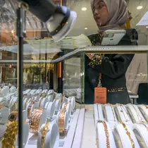 Penurunan ini terjadi setelah sebelumnya pada Minggu (13/4/2025) mencetak rekor hampir Rp2 juta per gram. (BAY ISMOYO/AFP)
