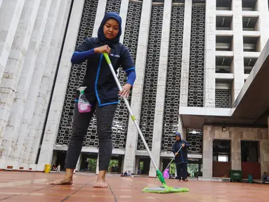 Pekerja wanita membersihkan lantai dalam rangka program Ramadan Tanpa Batas di Masjid Istiqlal, Jakarta, Kamis (15/06). Sebanyak 150 mitra Go-Clean dan driver Go-Jek bergotong royong membersihkan masjid. (Liputan6.com/Fery Pradolo)