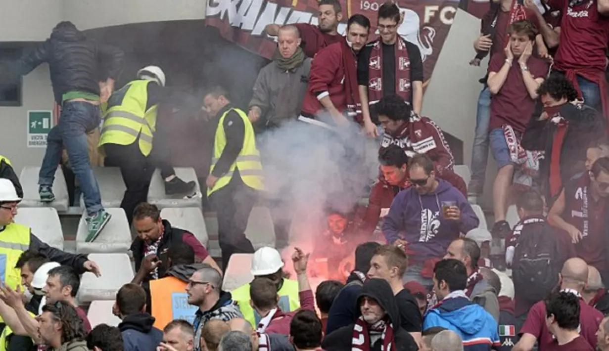 Pendukung Torino berhamburan setelah suar mendarat di antara mereka. (Dailymail)