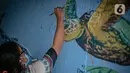 Mahasiswa Institut Kesenian Jakarta (IKJ) menyelesaikan pembuatan mural di kolong Jembatan Pegangsaan, Menteng, Jakarta, Selasa (26/1/2021). Pembuatan mural tersebut merupakan bagian dari pembangunan taman kolong jembatan oleh Pemprov DKI Jakarta. (Liputan6.com/Faizal Fanani)