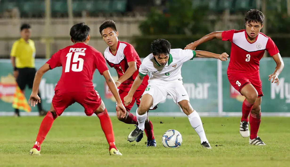 Muhammad Iqbal berusaha melewati pemain Filipina U-19 pada laga Piala AFF U-18 di Stadion Thuwunna, Myanmar, Kamis (7/9/2017). Iqbal mecetak dua gol untuk Indonesia. (Liputan6.com/Yoppy Renato)