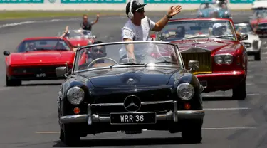 Pembalap Formula 1 Mercedes asal Jerman, Nico Rosberg menyapa pengemar saat duduk di atas mobil Mercedes-Benz klasik saat mengikuti parade jelang Grand Prix Formula 1 Malaysia di Sirkuit Internasional Sepang, Malaysia, (2/10). (REUTERS/Edgar Su)