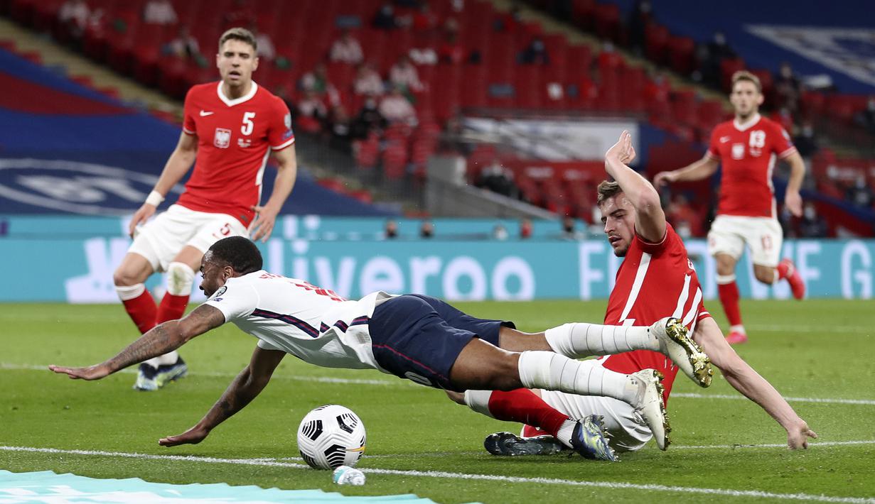 Gelandang Inggris, Raheem Sterling dijatuhkan bek Polandia, Michal Helik di dalam kotak penalti dalam laga lanjutan Kualifikasi Piala Dunia 2022 Zona Eropa Grup I di Wembley Stadium, London, Rabu (31/3/2021). Inggris menang 2-1 atas Polandia. (AP/Catherine Ivill/Pool)