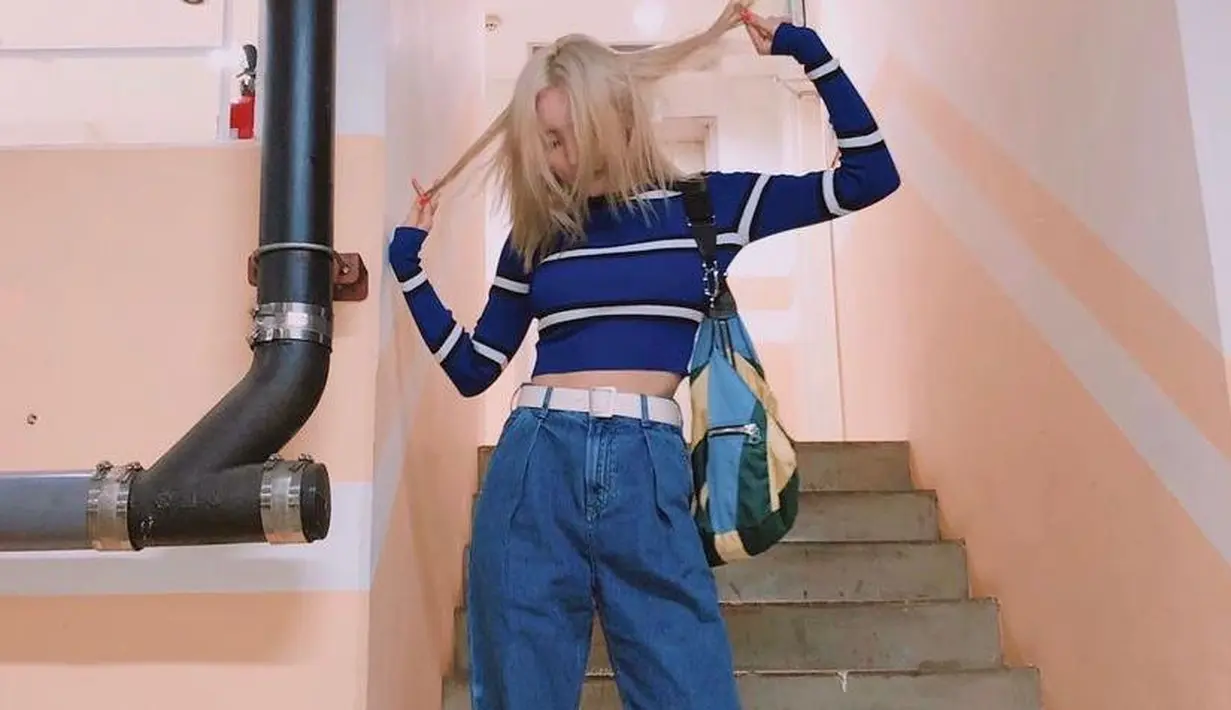 Crop top shirt motif stripe yang dipadukan dengan boyfriend jeans dan dilengkapi belt serta train shoes bikin tampilan makin kece seperti pelantun “Gashina”, Sunmi satu ini. (Instagram/miyayeah).