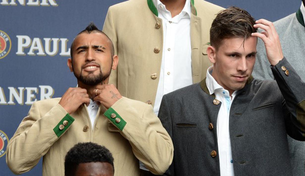 Pemain baru Munchen, Arturo Vidal, merapikan baju yang dikenakannya. (AFP Photo/Christof Stache)