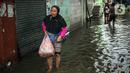 Warga beraktivitas saat banjir rob di Muara Angke, Jakarta, Jumat (25/11/2022). Badan Penanggulangan Bencana Daerah (BPBD) DKI Jakarta mengimbau agar warga di pesisir Jakarta mengantisipasi banjir pesisir atau rob selama 22-28 November 2022. (Liputan6.com/Faizal Fanani)