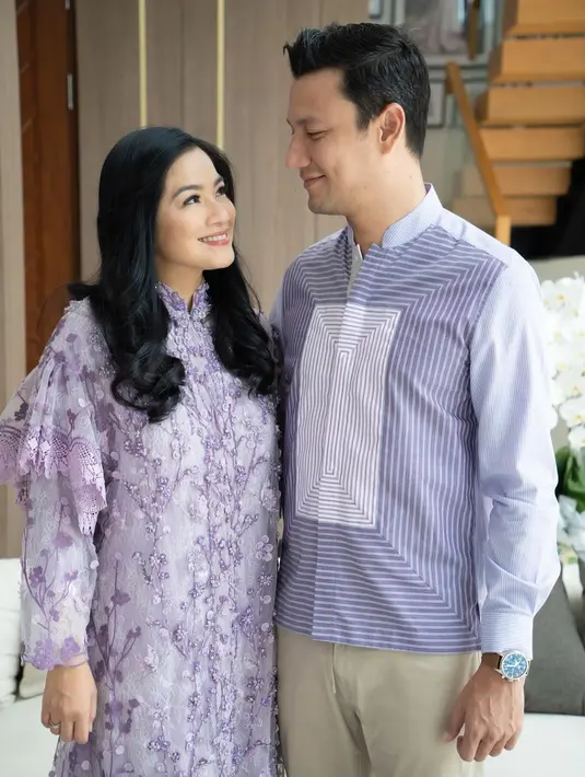 <p>Kalau untuk busana muslim, pilihan dress ungu yang senada dengan busana pria terlihat manis. Paduan celana warna khaki menjadi pilihan tepat untuk tampil tak mencolok. [Instagram/titi_kamall]</p>