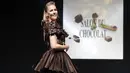 Wartawan Prancis-Inggris dan pembawa acara TV Sandy Heribert mengenakan kreasi yang dibuat dengan cokelat oleh koki pastry Hugues Pouget dan desainer Ricardo Davila selama Chocolate Fair (Salon du Chocolat) di Paris pada Rabu (27/10/2021). (GEOFFROY VAN DER HASSELT / AFP)