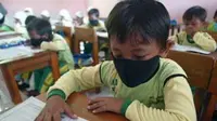 Siswa kelas I-B Madrasah Ibtidaiyah (MI) Tanfirul Afkar, Mojokerto, Jawa Timur, tepaksa menggunakan masker karena terganggu bau limbah pabrik pengolahan karet mentah PT. Bumi Nusa Makmur. (Antara)