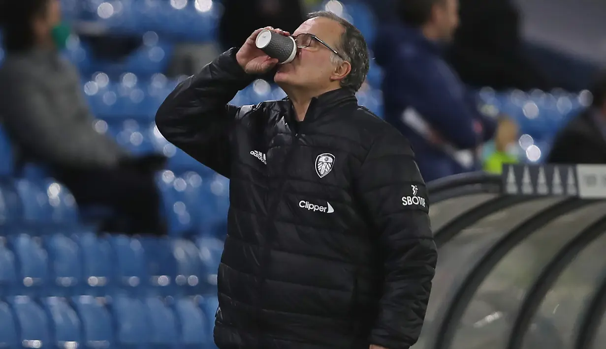 Usai memberikan instruksi kepada para pemainnya, Marcelo Bielsa meneguk air sejenak untuk melepaskan dahaga. (AFP/Molly Darlington/Pool)