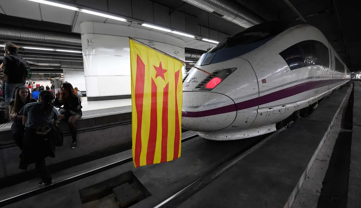 Sebuah bendera pro-kemerdekaan Catalonia ditempatkan di sebuah kereta oleh para pemrotes yang memblokir jalur di Stasiun Sants di Barcelona (8/11). (AFP Photo/Lluis Gene)