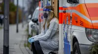 Pekerja medis menunggu seorang anak bersiap-siap untuk tes cepat di dalam mobil van tes Corona di Frankfurt, Jerman, Senin (15/11/2021). Jumlah infeksi Corona Covid-19 kembali meningkat di Jerman. (AP Photo/Michael Probst)