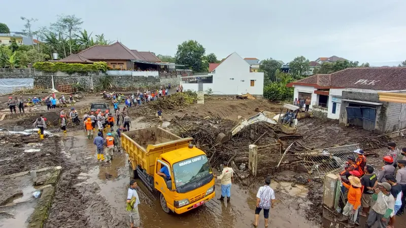 Tim SAR Gabungan menggunakan alat berat membersihkan sisa material banjir bandang di Desa Bulukerto, Kota Batu pada Jumat, 5 November 2021 (Liputan6.com/Zainul Arifin)