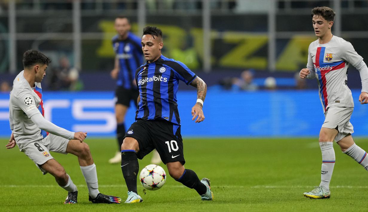 Penyerang Inter Milan Lautaro Martinez berebut bola melawan gelandang Barcelona Pedri  pada matchday ketiga Grup C Liga Champions 2022/2023 di Giuseppe Meazaa, Rabu dini hari WIB (5/10/2022). Gol kemenangan tim wakil Italia dilesakkan Hakan Calhanoglu. (AP Photo/Antonio Calanni)