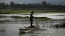 Seorang nelayan India di atas perahu memancing ikan di air banjir surut di sawah di pinggiran Gauhati, India, Senin (14/9/2020). (AP Photo / Anupam Nath)