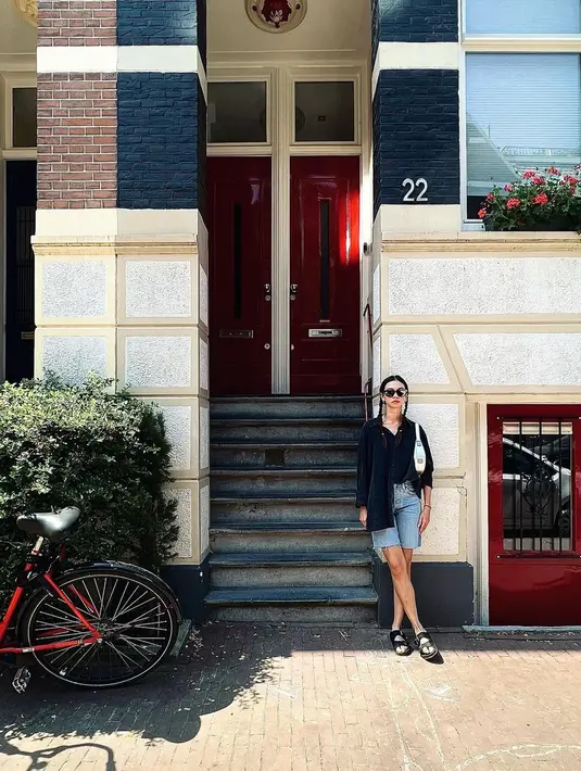 Berpose di jalanan kota Amsterdam, Yuki Kato memadukan kemeja panjang dengan celana pendek denim dan sandal mule. [Foto: IG/yukikt].