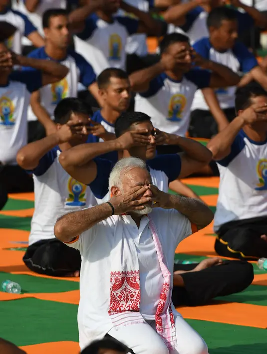 Perdana Menteri India, Narendra Modi memimpin pelaksanaan yoga massal pada Hari Yoga Internasional di Dehradun, Kamis (21/6). Modi adalah tokoh utama yang berhasil melobi PBB untuk menyatakan 21 Juni sebagai Hari Yoga Internasional. (AFP/PRAKASH SINGH)