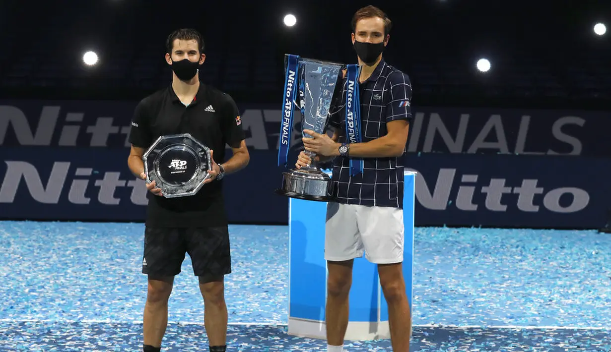 Petenis Rusia Daniil Medvedev (kanan) memegang trofi juara ATP World Finals bersama petenis Austria Dominic Thiem di O2 Arena, London, Inggris, Minggu (22/11/2020). Daniil Medvedev menjuarai ATP World Finals usai mengalahkan Dominic Thiem pada babak final. (AP Photo/Frank Augstein)