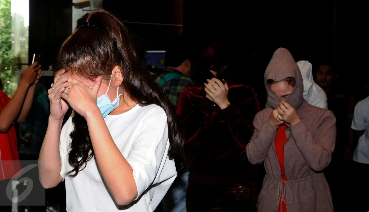 Beberapa perempuan warga negara asing illegal yang terjaring operasi pengawasan menutupi wajah saat rilis di Ditjen Imigrasi, Jakarta, Jumat (13/1). Diduga, para WNA tersebut bekerja sebagai pekerja seks komersial (PSK). (Liputan6.com/Helmi Fithriansyah)