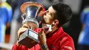 Petenis Serbia, Novak Djokovic, mencium trofi usai menjuarai Italia Terbuka di Roma, Senin (21/9/2020). Djokovic mengalahkan petenis Argentina, Diego Schwartzman, dengan skor 7-5 dan 6-3. (Alfredo Falcone/LaPresse via AP)