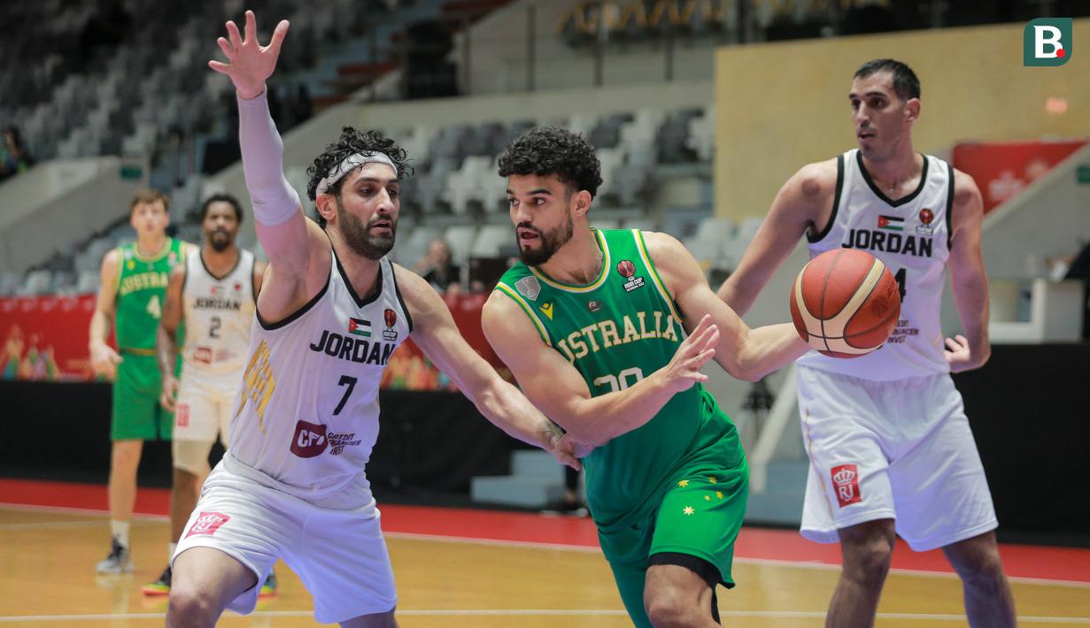 Pebasket Australia, Samuel Mcdaniel (tengah) berusaha melewati pebasket Yordania, Ahmad Alharmarshes saat matchday pertama Grup A FIBA Asia Cup 2022 antara Timnas Yordania melawan Timnas Australia di Istora Senayan, Jakarta, Selasa (12/07/2022). (Bola.com/Bagaskara Lazuardi)