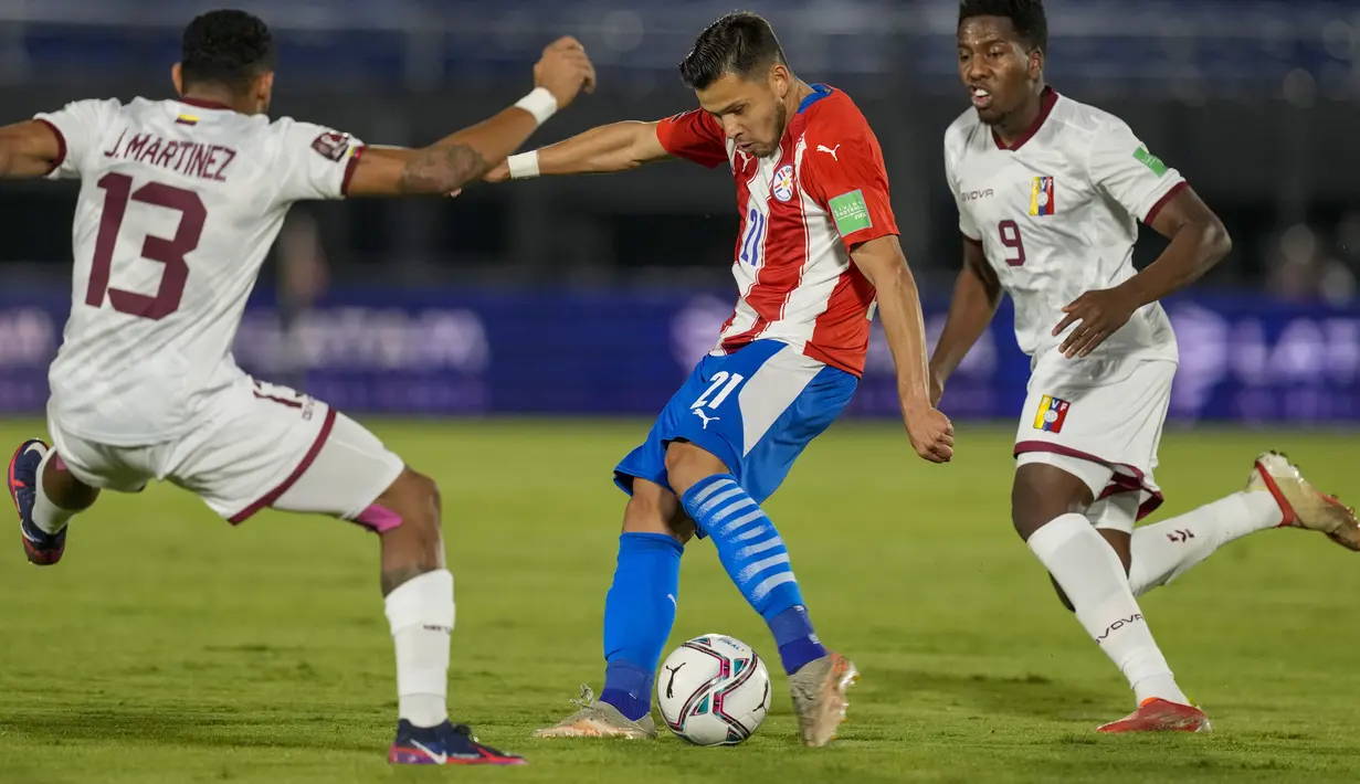 Gelandang Venezuela, Jose Martinez memblokir gelandang Paraguay, Oscar Romero dalam lanjutan Kualifikasi Piala Dunia 2022 zona Conmebol di Estadio Defensores del Chaco, Asuncion, Jumat (10/9/2021) pagi. Paraguay memetik kemenangan tipis 2-1 atas Venezuela. (AP/Jorge Saenz)