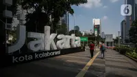 Warga melintasi Jalan Sudirman pada pemberlakukan PPKM darurat hari kedua di Jakarta, Minggu (4/7/2021). Pemerintah secara resmi menerapkan pemberlakuan pembatasan kegiatan masyarakat (PPKM) darurat di Jawa dan Bali, termasuk DKI Jakarta, pada 3-20 Juli 2021. (Liputan6.com/Johan Tallo)