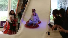 Ekspresi seorang anak berseluncur di perosotan es di Lippo Mal Puri, Jakarta, Jumat (22/12). Jelang Natal banyak pusat perbelanjaan mendekor bangunannya bernuansa natal untuk menarik daya tarik minat masyarakat. (Liputan6.com/Angga yuniar)