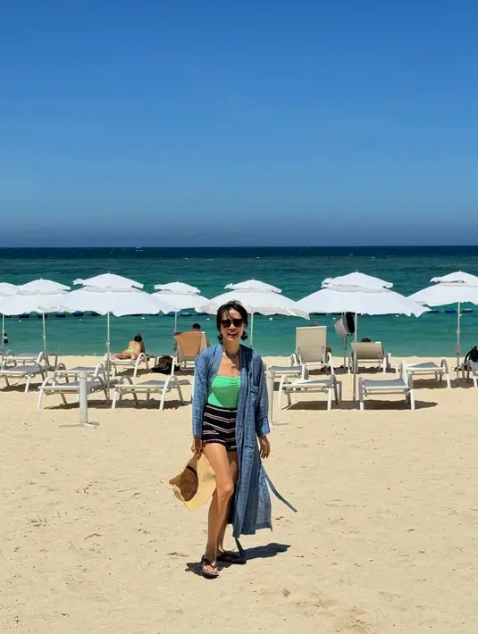 Menikmati panasnya pantai, ia kenakan strapless hijau dengan celana pendek rajut bergaris dan outer biru [@yejinhand]