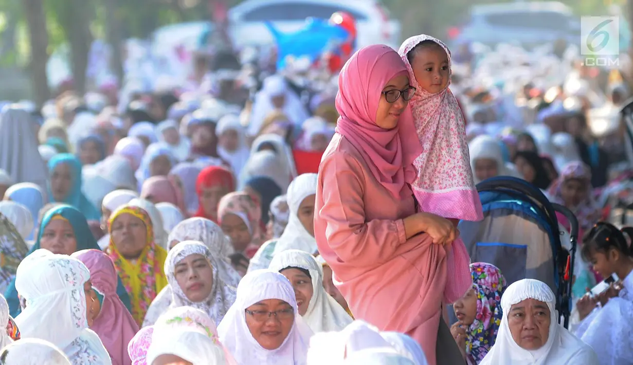 Seorang wanita menggendong anak usai melaksanakan salat Idul Fitri di kawasan Pelabuhan Sunda Kelapa, Jakarta, Rabu (5/6/2019). Umat muslim seluruh Indonesia merayakan Hari Raya Idul Fitri 1440 Hijriah setelah sebelumnya melaksanakan puasa Ramadan selama sebulan penuh. (merdeka.com/Arie Basuki)