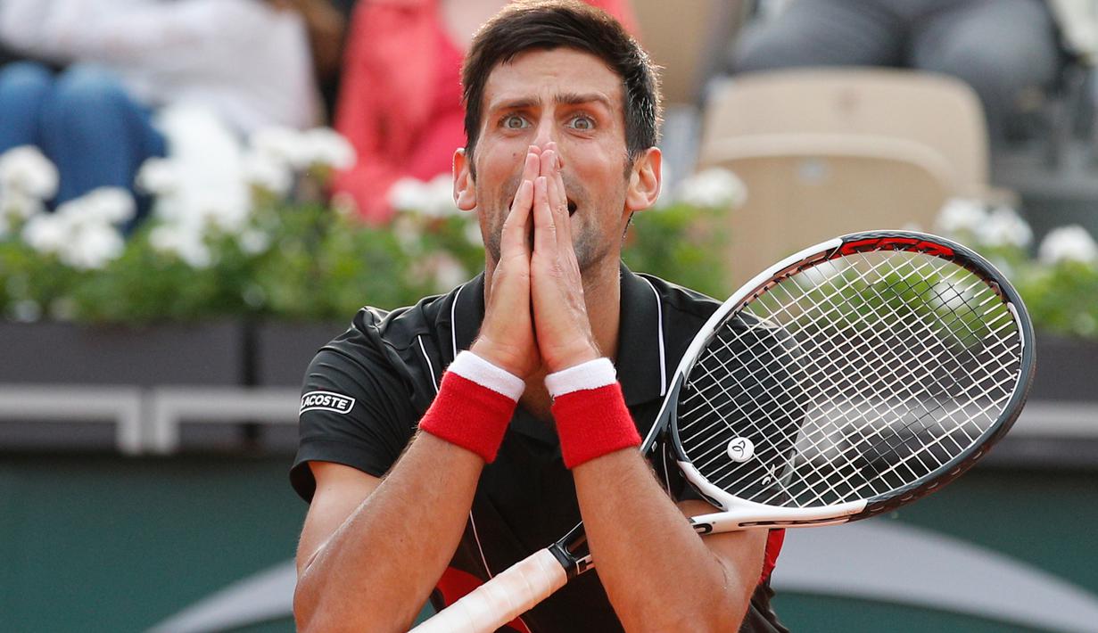 Reaksi petenis Serbia, Novak Djokovic saat melawan petenis Italia Marco Cecchinato pada perempatfinal Prancis Terbuka 2018 di stadion Roland Garros, Selasa (5/6). Djokovic dikalahkan petenis non-unggulan dalam duel empat set. (AP/Christophe Ena)