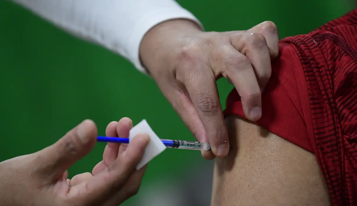 Perawat menyuntikkan dosis ketiga vaksin COVID-19 AstraZeneca di Centro de Estudios Superiores Navales (CENCIS) di Ibu kota Meksiko, Mexico City, Selasa (7/12/2021). Ibu kota Meksiko pada hari Selasa mulai memberikan vaksinasi booster untuk orang yang berusia di atas 60 tahun. (Pedro PARDO/AFP)