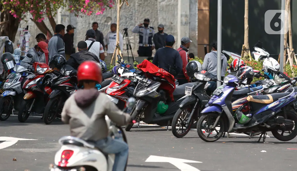 Deretan motor pengemudi ojek terparkir di jalur khusus angkutan umum Stasiun Tanah Abang, Jakarta Pusat, Jumat (5/6/2020). Stasiun Tanah Abang punya wajah baru dengan menyediakan jalur khusus angkutan umum mulai dari angkot, bajaj, hingga ojek. (Liputan6.com/Johan Tallo)