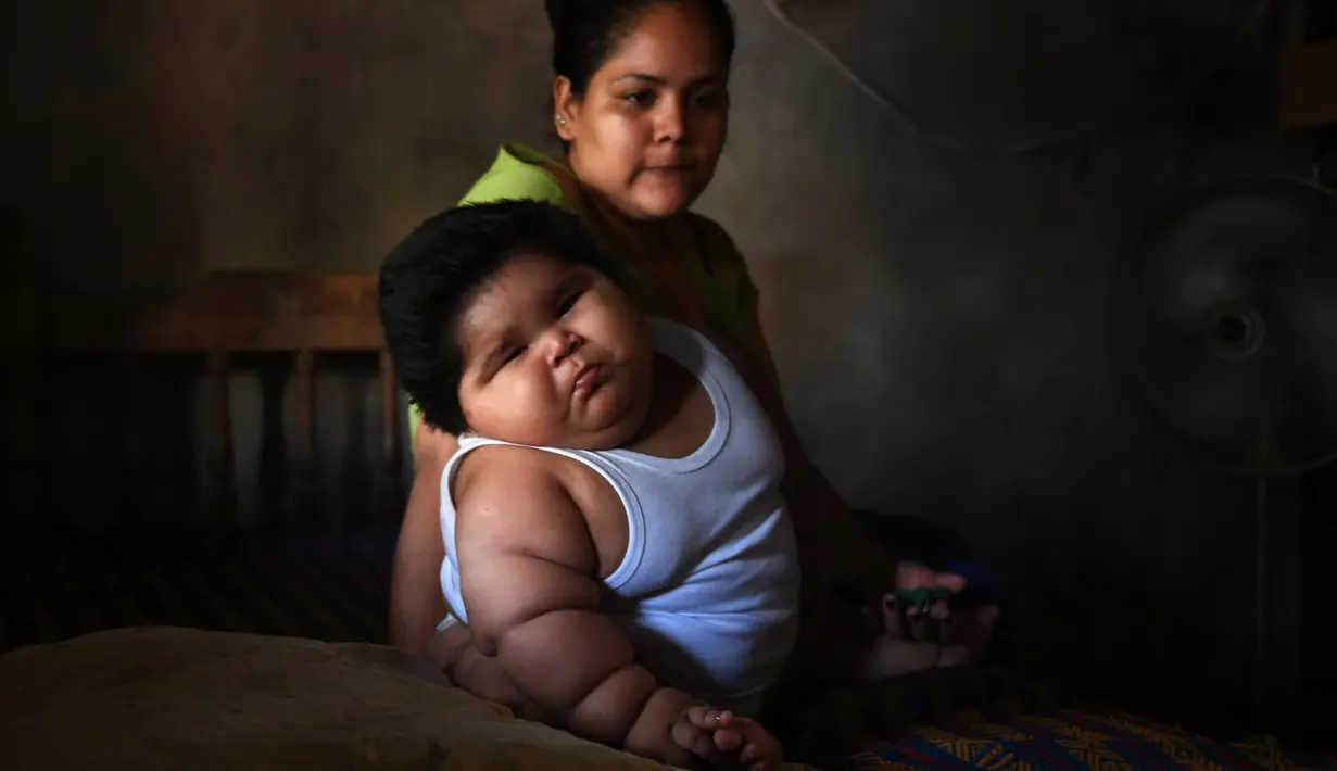 Bayi berusia sepuluh bulan bernama Luis Gonzales bersama ibunya, Isabel Pantoja di rumah mereka di Tecoman, negara bagian Colima, Meksiko (8/11). (AFP Photo/Pedro Pardo)