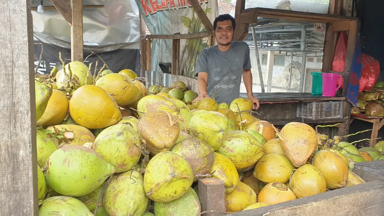 Suhe ‘Kelapa Muda’, salah satu pedagang kelapa muda di bilangan Alun-alun Tarogong, Garut, terlihat tengah menjajakan barang dagangnnya menjelang iftor Ramadan, Selasa (5/4/2022).
