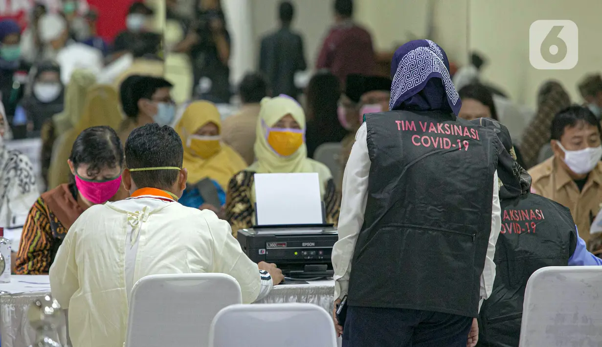 Petugas kesehatan mendata guru sebelum menjalani vaksinasi COVID-19 di SMA 70, Jakarta, Rabu (25/2/2021). Sebanyak 600 orang dari profesi guru, tenaga kependidikan, dan dosen akan divaksin COVID-19 hari ini. (Liputan6.com/Faizal Fanani)
