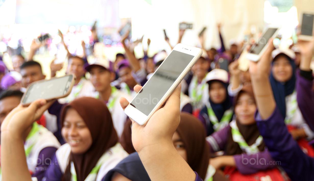 Peserta Raimuna Nasional XI saat mengangkat handphone untuk belajar Vlog jurnalistik di Bumi Perkemahan Cibubur, Selasa (15/8/2017). Kegiatan ini sebagai bentuk dari pembelajaran jurnalistik olahraga. (Bola.com/Nicklas Hanoatubun)