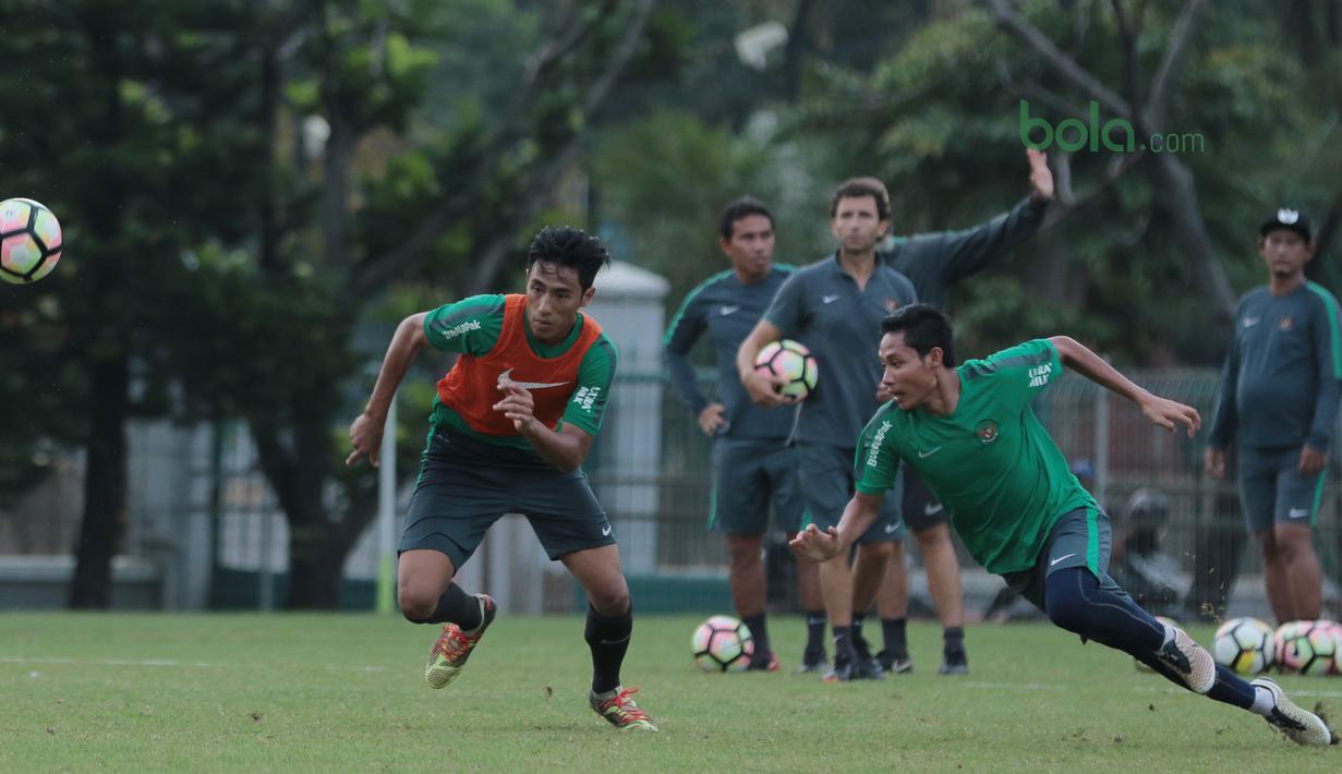 Evan Dimas (kanan) berebut bola dengan Hanif Sjahbandi saat berlatih di Lapangan ABC, Senayan,  (24/4/2018). Timnas akan mengikuti turnamen PSSI Anniversary 27 April-3 Mei 2018. (Bola.com/Nicklas Hanoatubun)