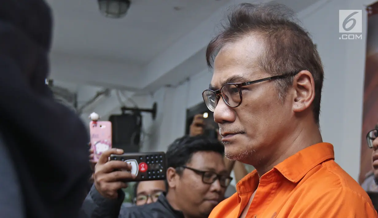 Tersangka Tio Pakusadewo saat jumpa pers di Dit Narkoba Polda Metro Jaya, Jakarta, Jumat (22/12). Aktor Tio Pakusadewo di tangkap polisi terkait kepemilikan tiga bungkus plastik klip sabu 1,06 gram. (Liputan6.com/Herman Zakharia)