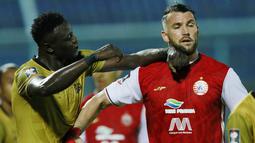 Striker Persija Jakarta, Marko Simic (kanan) saling dorong dengan striker Bhayangkara Solo FC, Ezechiel N'Douassel, pada laga Piala Menpora 2021 di Stadion Kanjuruhan, Malang, Rabu (31/3/2021). Persija Menang dengan skor 2-1. (Bola.com/M Iqbal Ichsan)