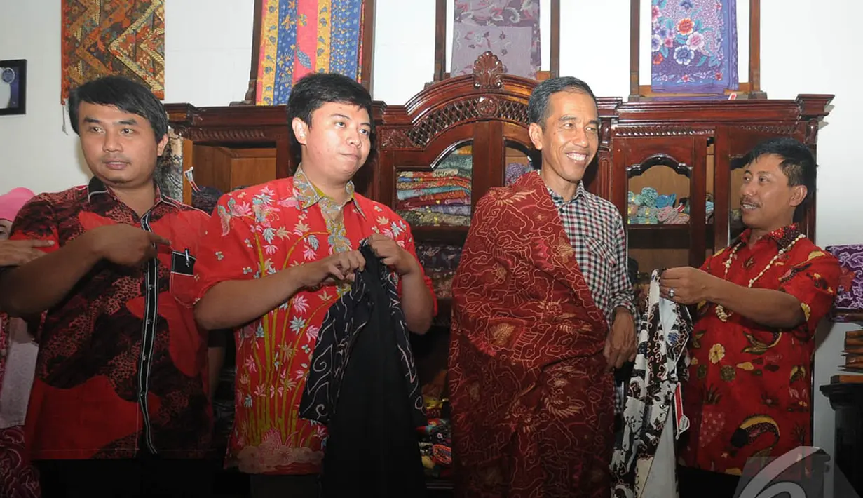 Jokowi mencoba kain batik yang akan dibelinya saat mampir di salah satu toko batik di Cirebon, Jawa Barat , Rabu (18/6/2014) (Liputan6.com/Herman Zakharia).