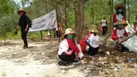 warga dan siswa saat memberishkan sampah di taman pendidikan mangrove Labuhan, Bangkalan