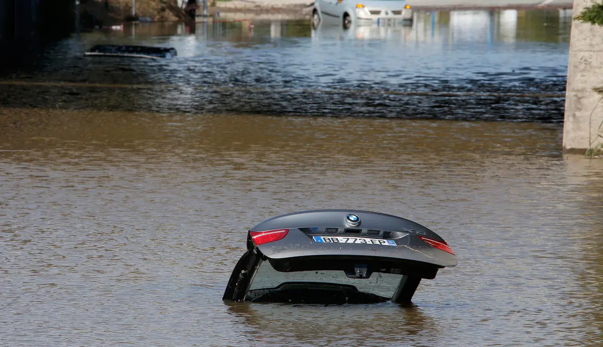 Sebuah mobil terendam banjir yang disebabkan hujan deras di Mandelieu, Prancis, Minggu (4/10/2015). Akibat peristiwa itu, sebanyak 16 warga dilaporkan tewas. (REUTERS/Eric Gaillard)  