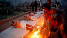 Umat Hindu Nepal berguling di tepi sungai Hanumante saat festival Madhav Narayan di Bhaktapur, Nepal (31/1). Ritual ini untuk persembahan kepada Dewi Swasthani dan Dewa Siwa. (AP Photo / Niranjan Shrestha)