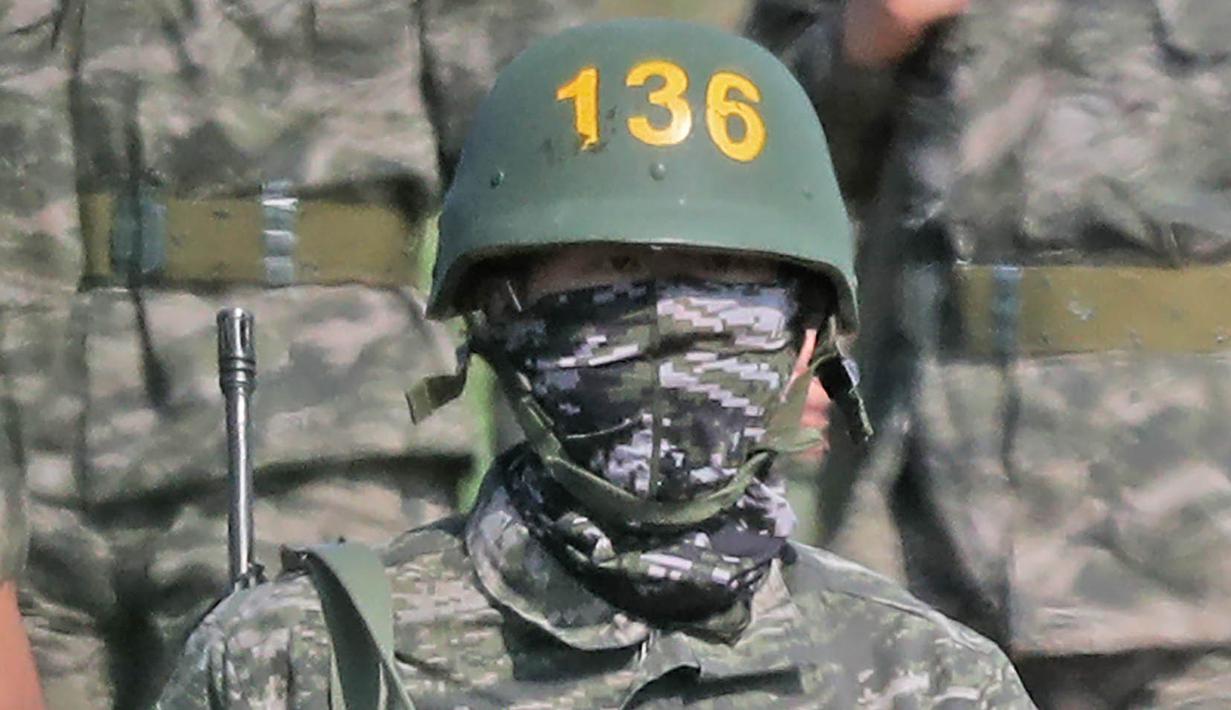 Pemain Tottenham Hotspur, Son Heung-min, berseragam militer lengkap dengan senjata saat mengikuti wajib militer di Korsel, (6/5/2020). Penundaan Premier League karena virus corona dimanfaatkan Son Heung-min untuk mengikuti program wajib militer. (AFP/STR)
