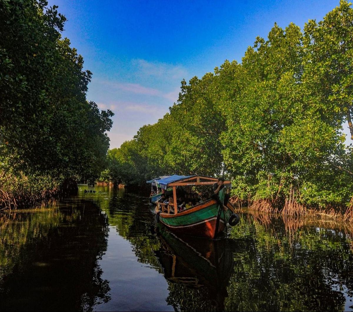 Perahu nelayan yang membawa wisatawan melewati kawasan mangrove di Sunge Jingkem di Kp. Sembilangan, Tarumajaya, Kabupaten Bekasi, Sabtu (13/4/2024). Destinasi ini menawarkan ekosistem mangrove yang indah dan unik untuk wisatawan yang mencari pengalaman a